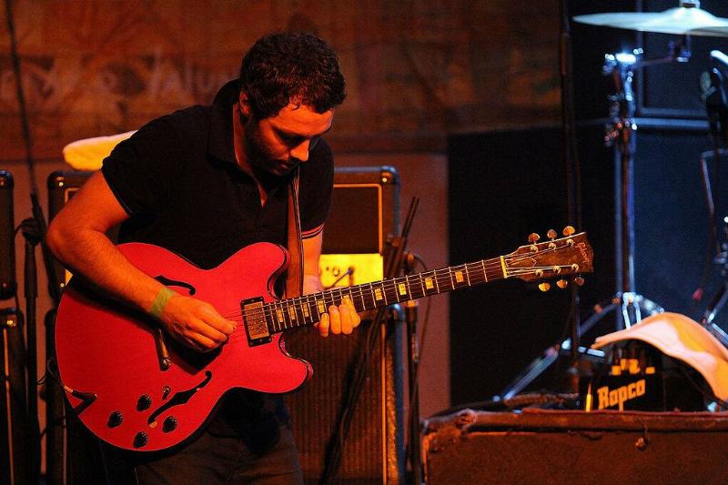 Stuart Jones of the Sunshine Underground playing the guitar onstage 