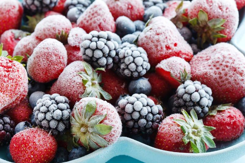 Variety of frozen berries in a blue bowl