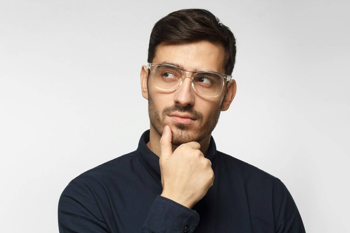 Man looking to the side, with his chin resting in one of his hands