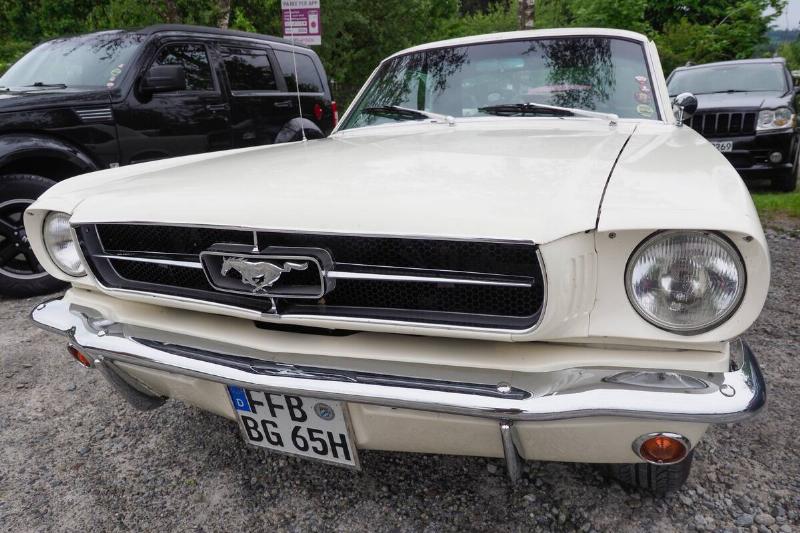 Ford Mustang parked in a gravel lot, next to another vehicle