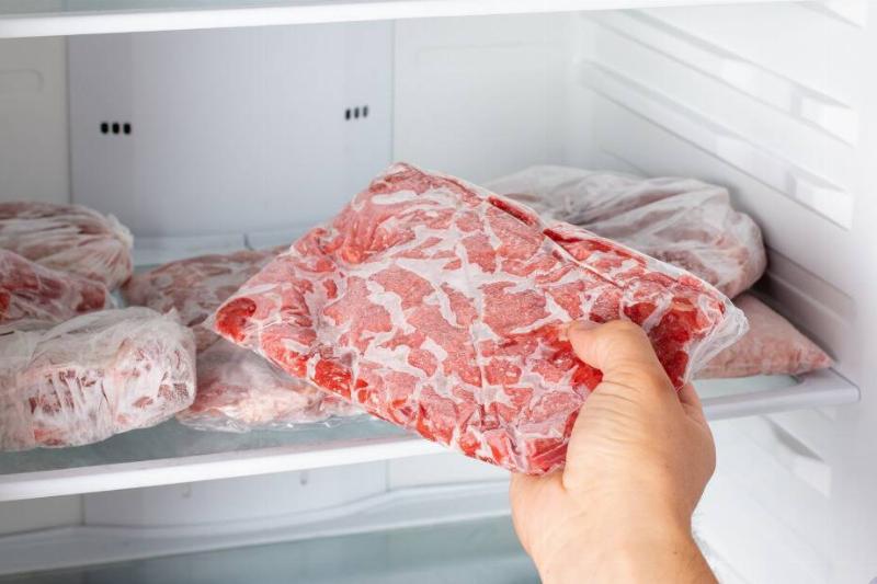 Person off-camera removing meat from a freezer