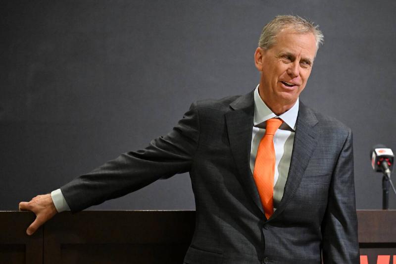 Todd Monken wearing a suit, standing in front of a podium
