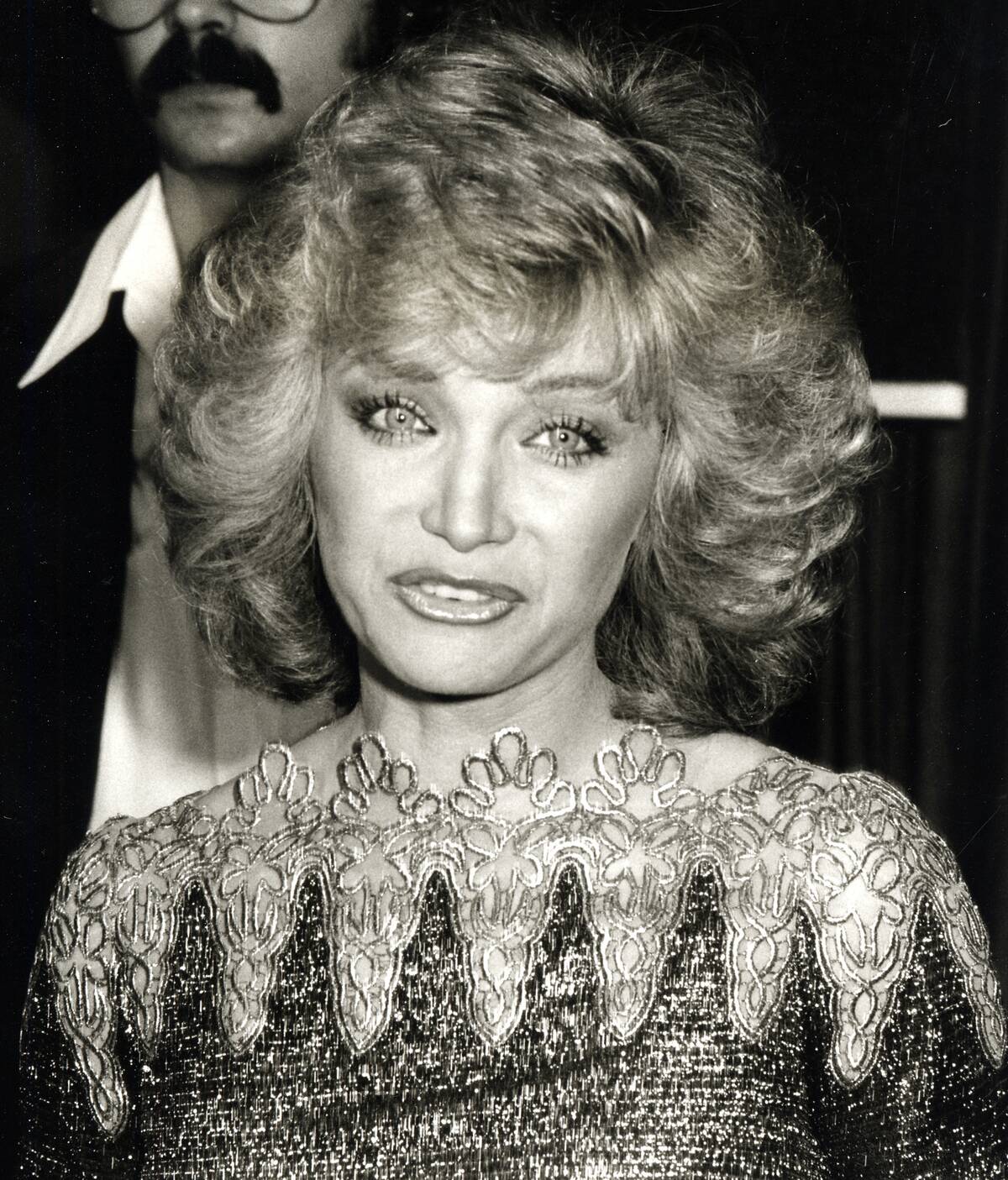 Barbara Mandrell standing in front of a man