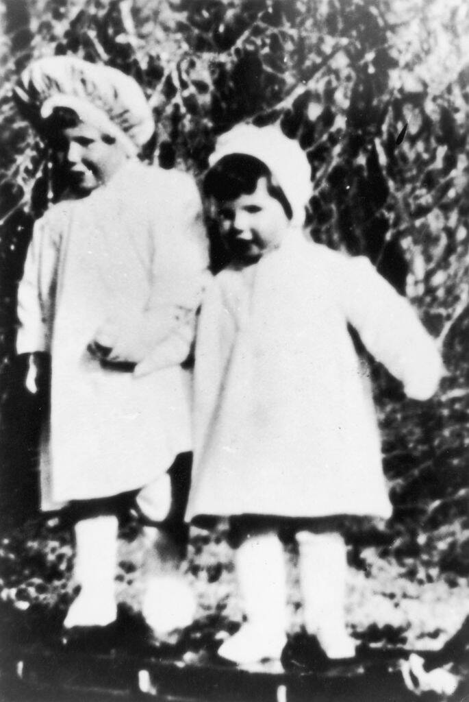 Tom and Katharine Hepburn walking together outside as toddlers