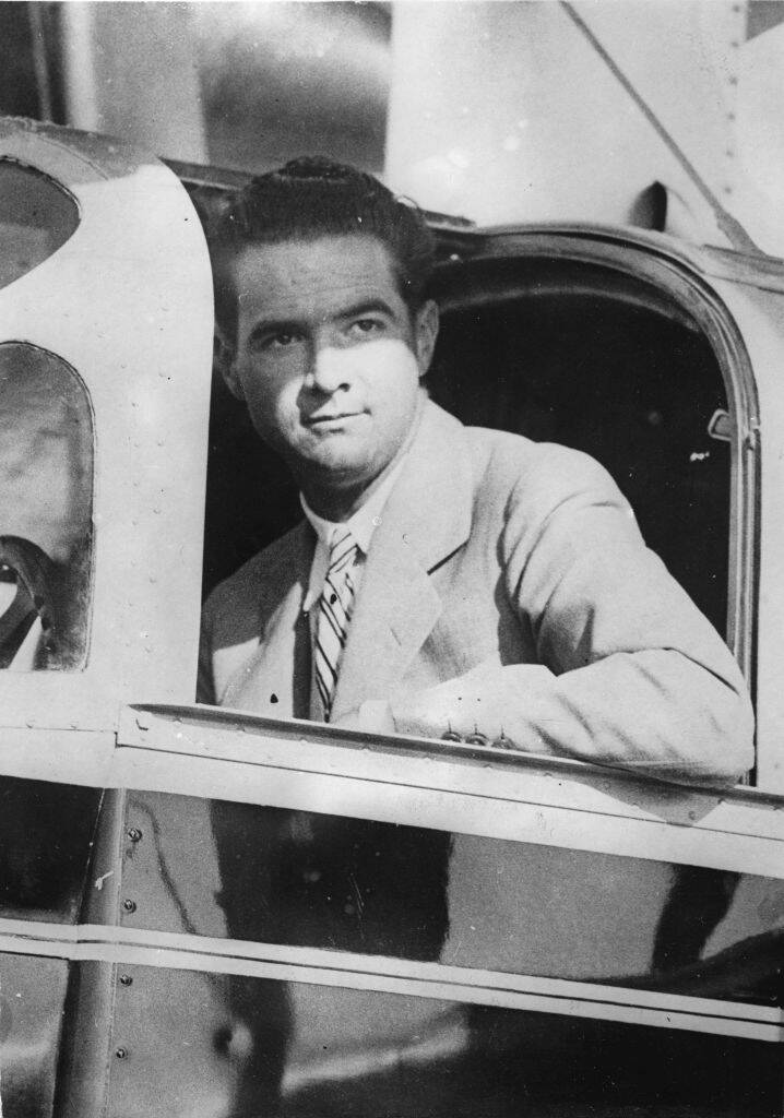 Howard Hughes sitting in the cockpit of an aircraft