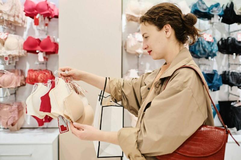 Woman looking at a bra in the middle of a lingerie store