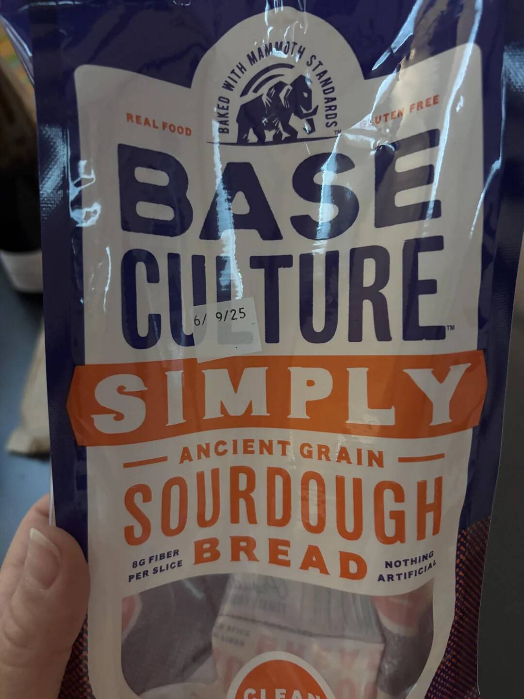 Person holding up a loaf of Base Culture sourdough bread