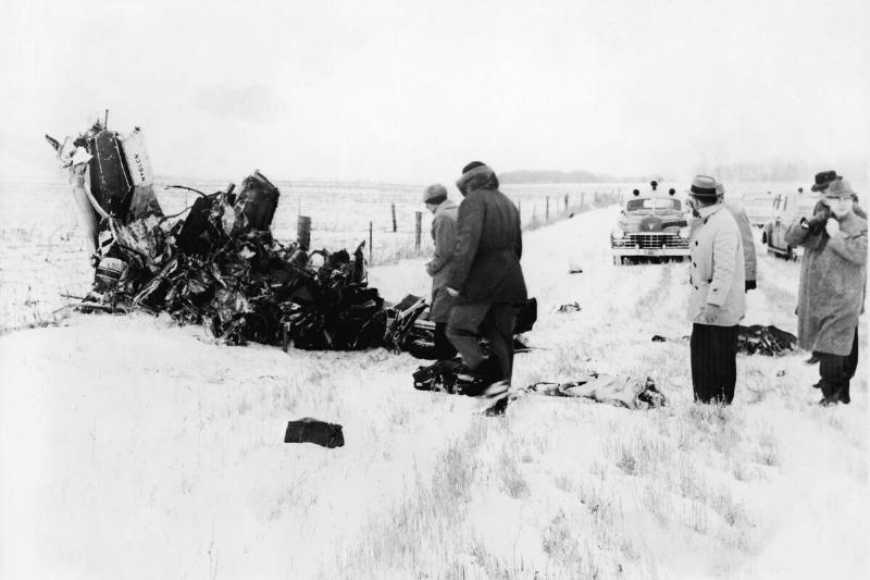 Men standing around the wreckage of an aircraft in a snowy field