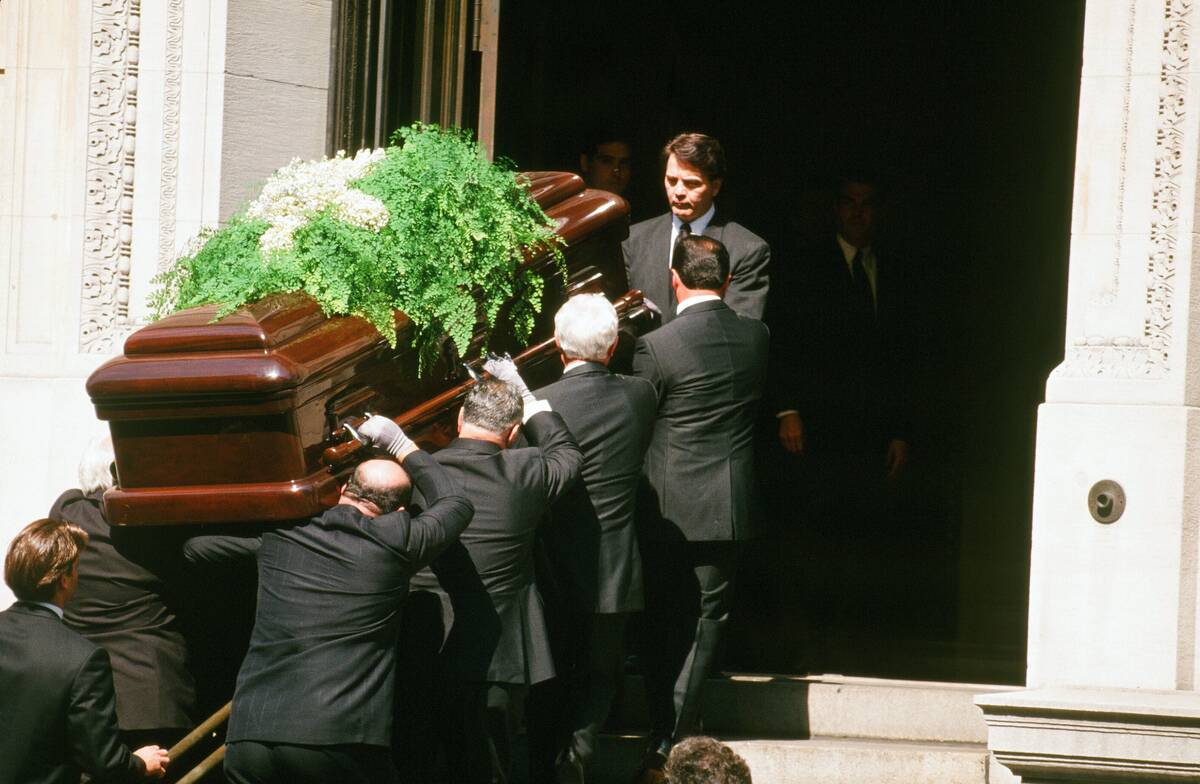 Men carrying a coffin into a church