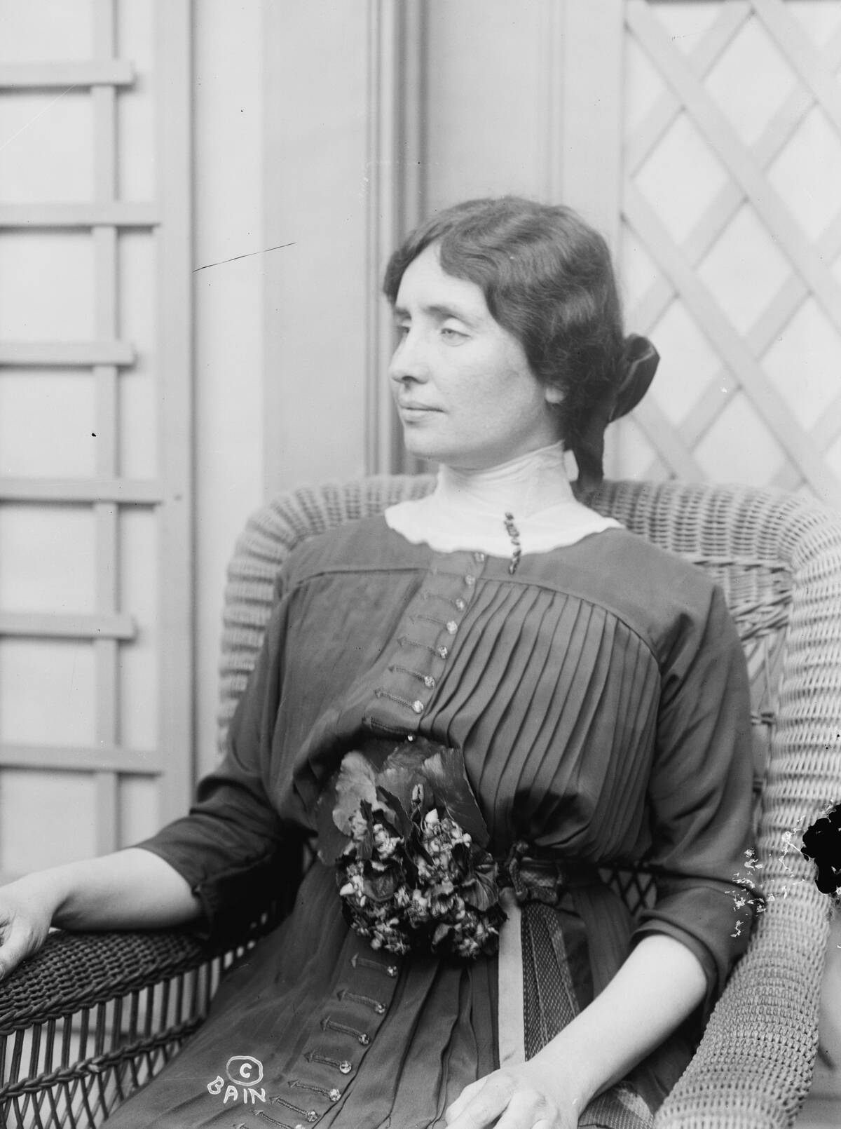 Helen Keller sitting in a wicker chair