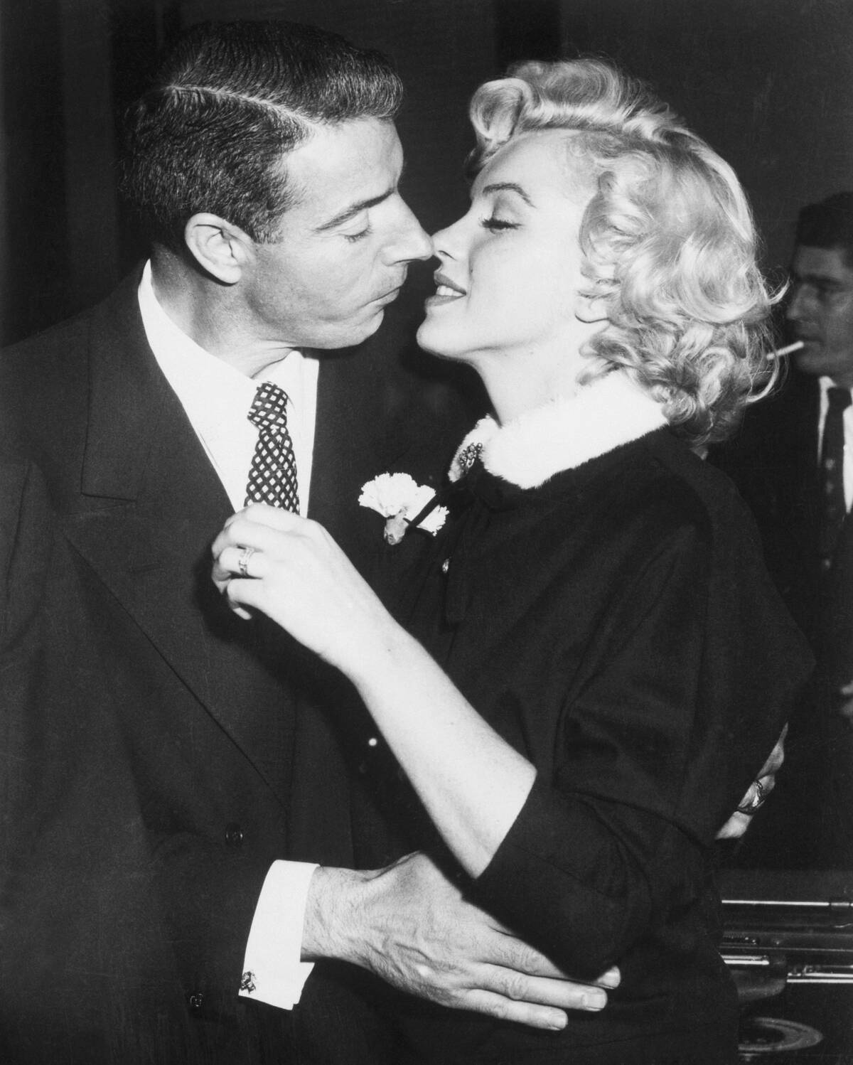 Joe DiMaggio and Marilyn Monroe moving in to kiss each other