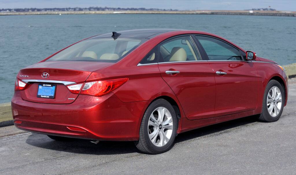 Red 2013 Hyundai Sonata parked near water