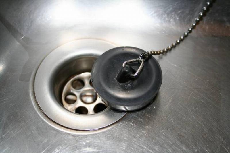 Rubber plug placed on the corner of the drain of a metal sink