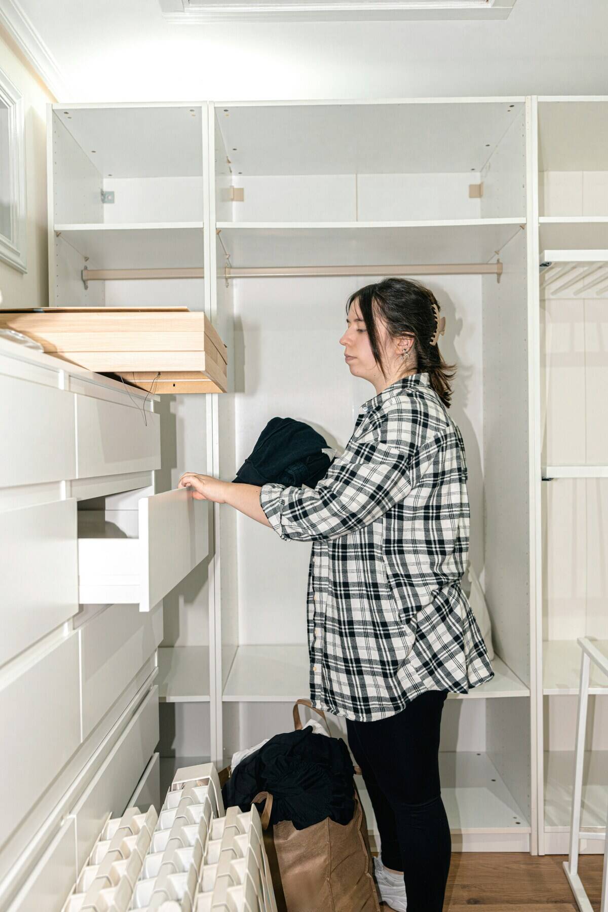Woman putting an item of clothing into a drawer
