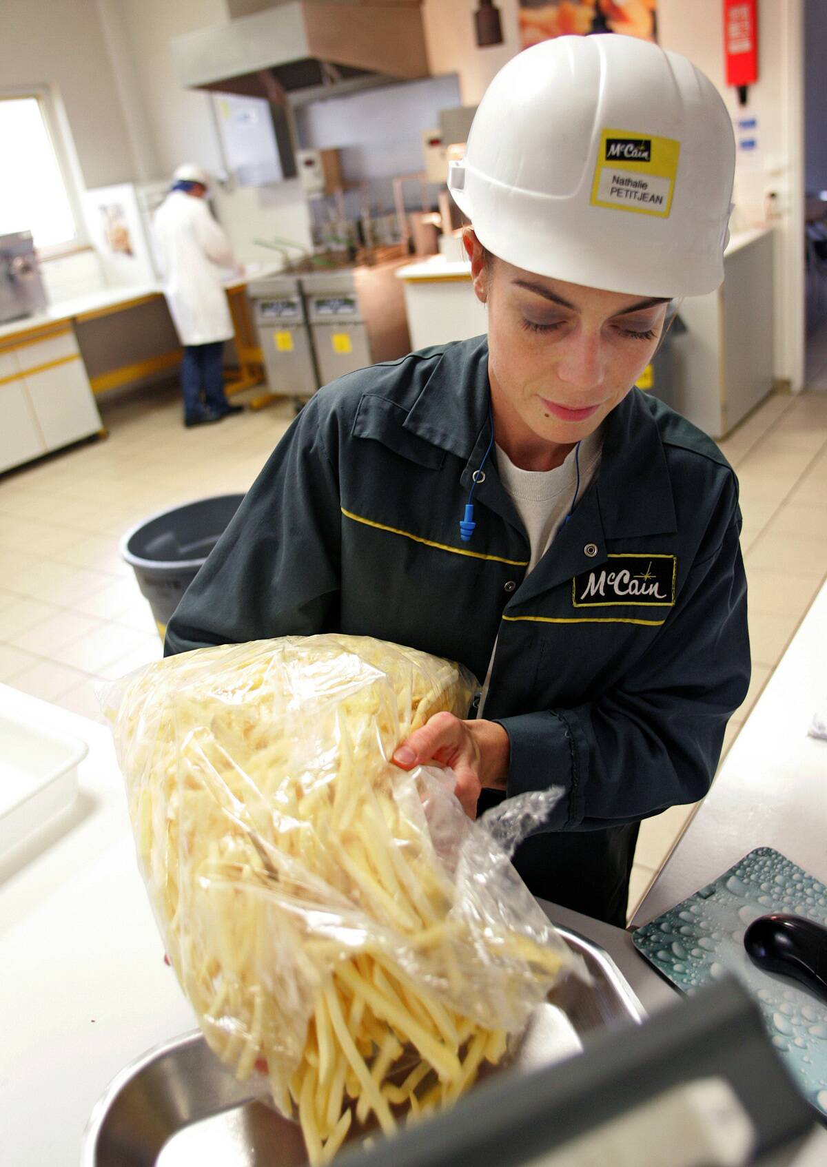 Woman pouring french fries into a machine