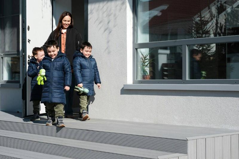 Mother and three children leaving a house through the front door