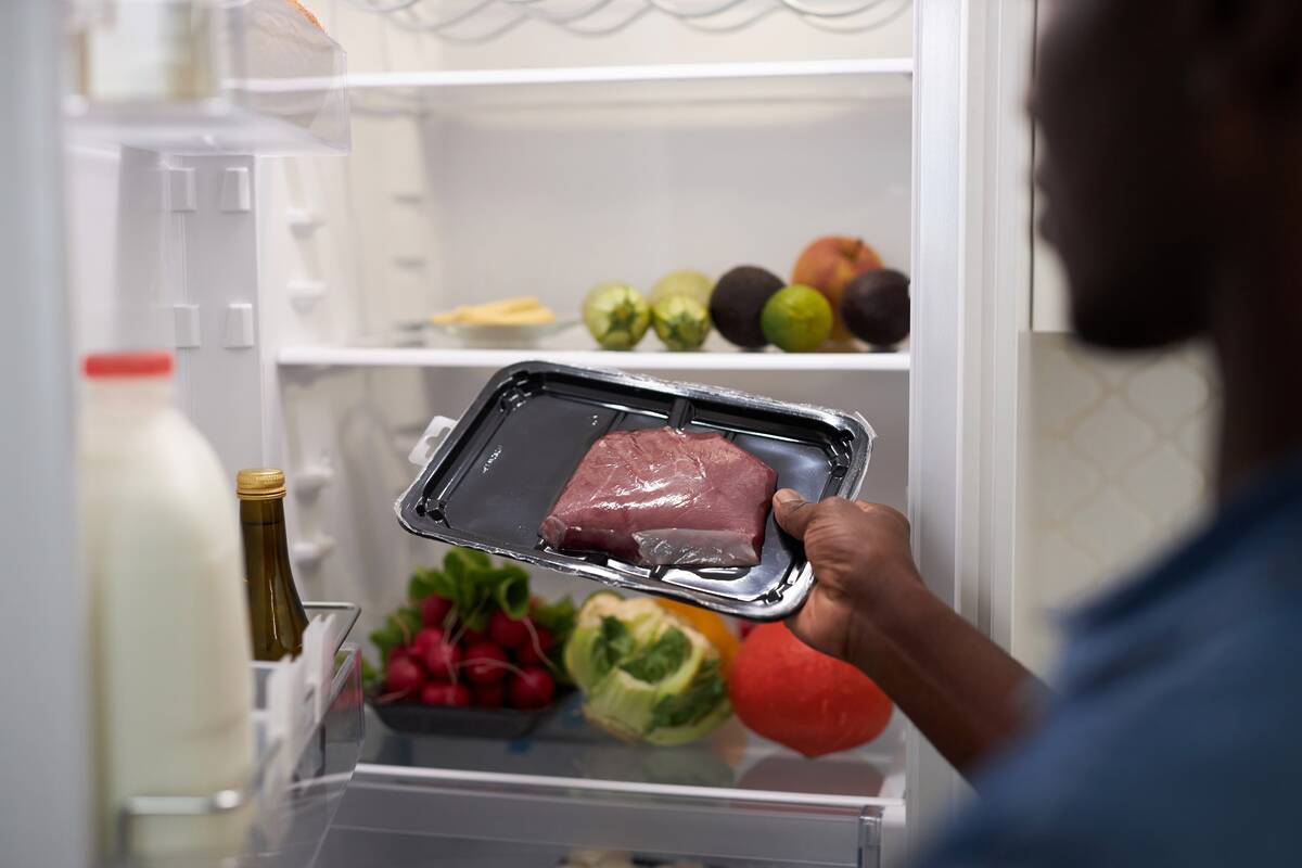 Man taking a package of meat from the fridge