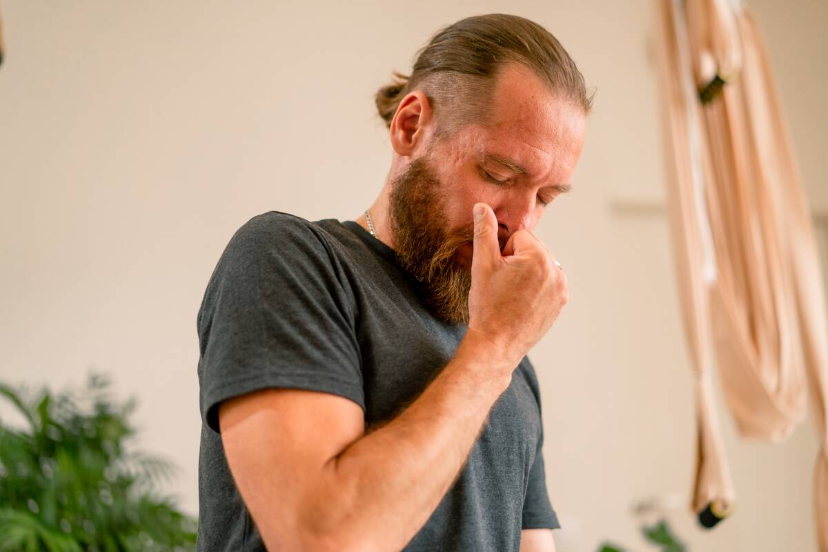 Man plugging his nose with her fingers