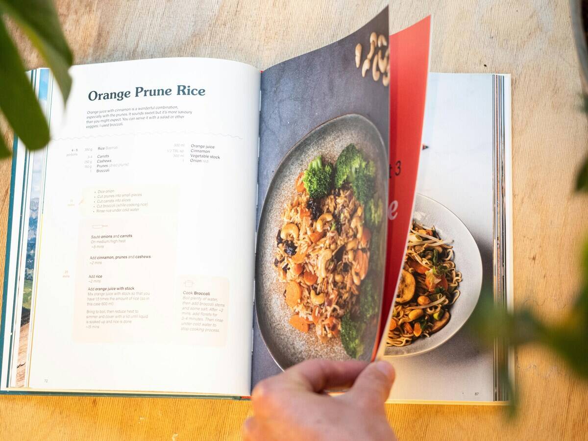 Person off-screen flipping through a cookbook