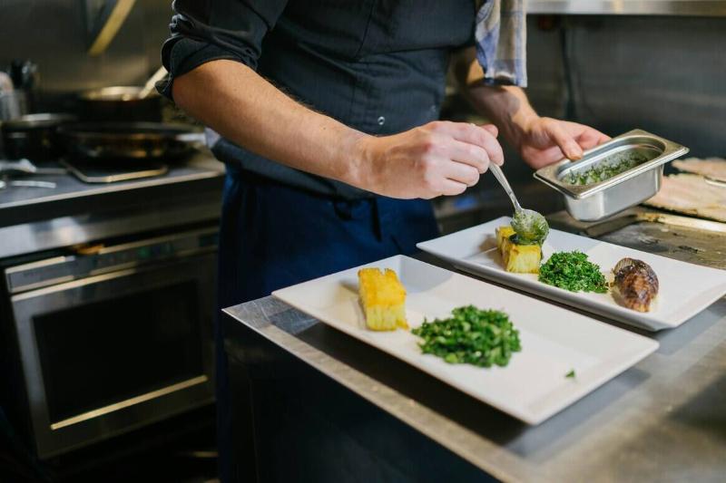 Chef plating food on two plates