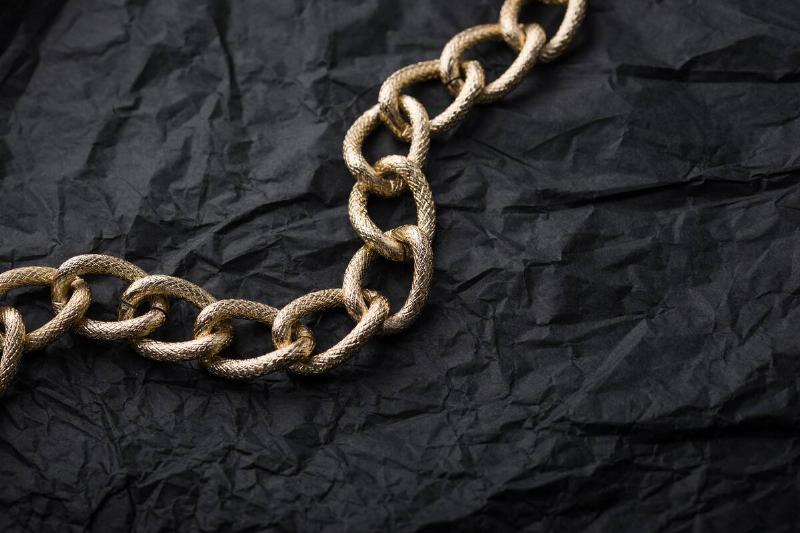 Gold chain on black tissue paper