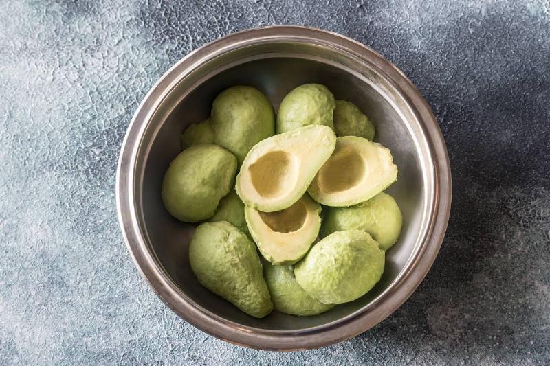 Bowl of halved avocados