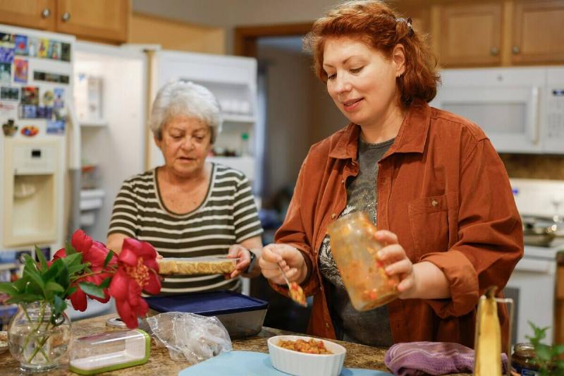 Two women making food at a kitchen counter