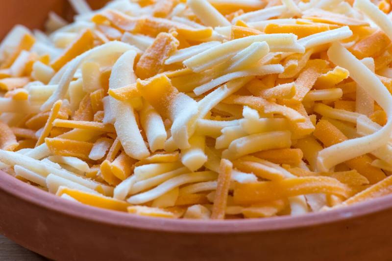 Close-up of a bowl of shredded cheese