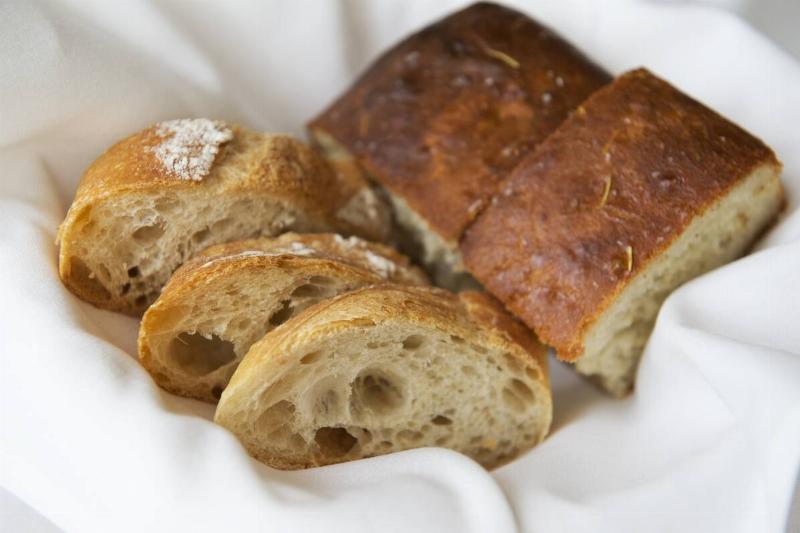 Sliced bread in a basket, laying on a white cloth