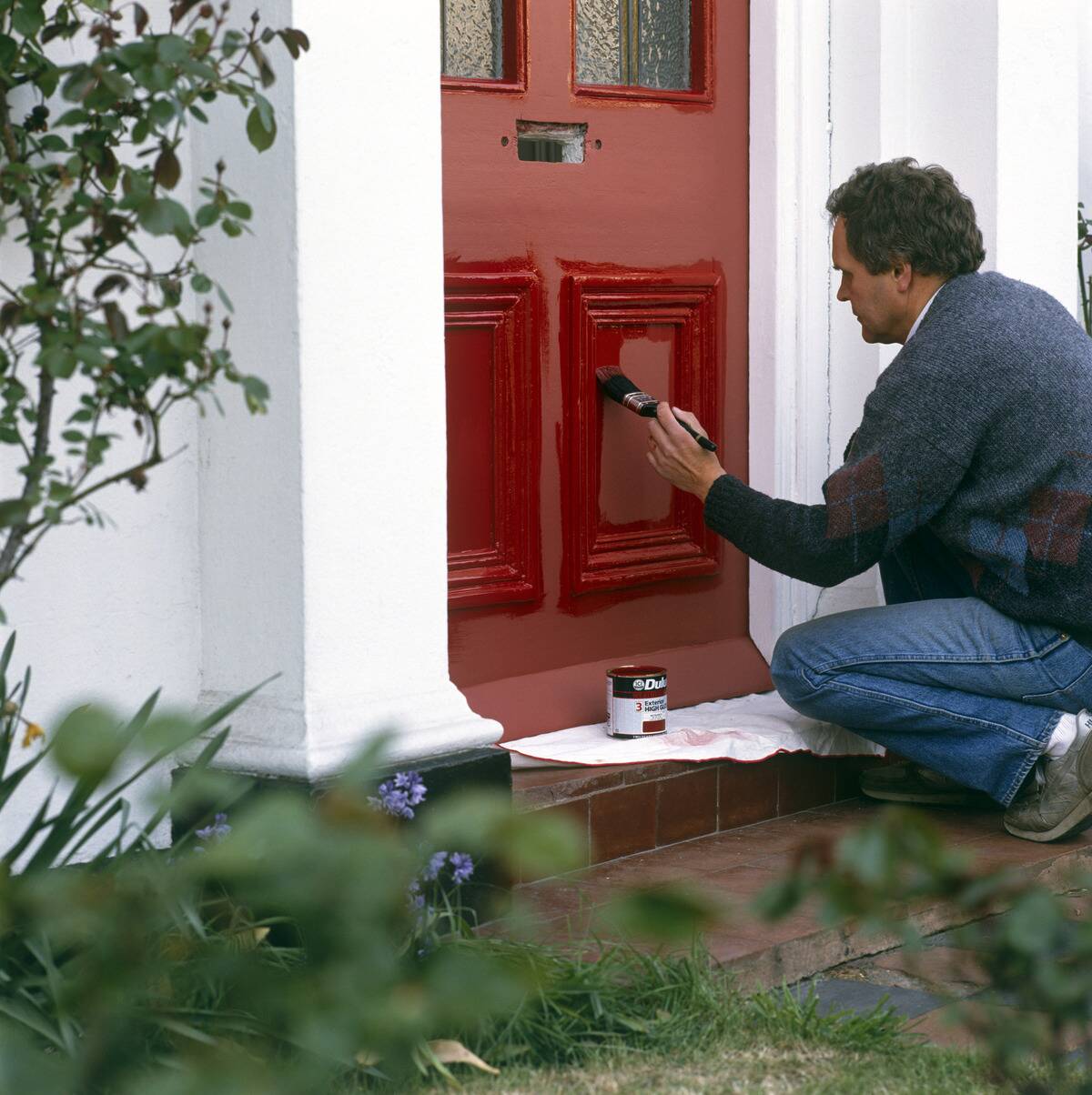 Painting a front door with bright red paint