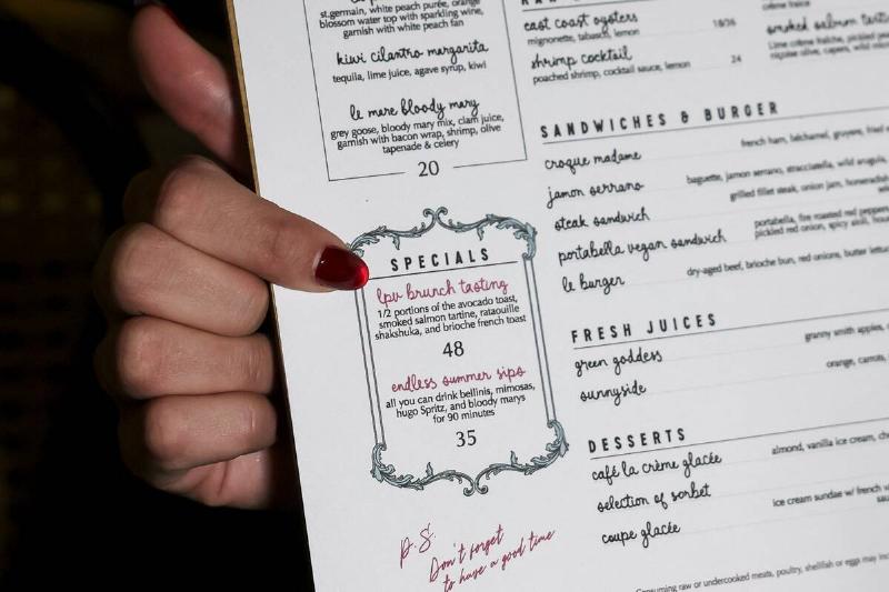 Close-up of a person pointing at a restaurant menu
