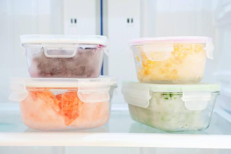 Four containers with food in a freezer