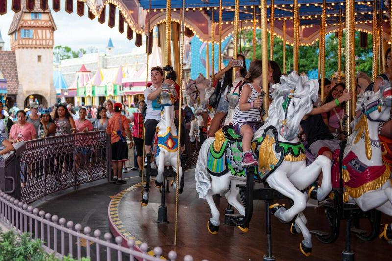 People riding in a carrousel amusement park ride at Walt