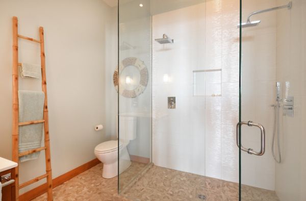 Lovely modern bathroom uses natural tones and glass shower space to create a refreshing feel