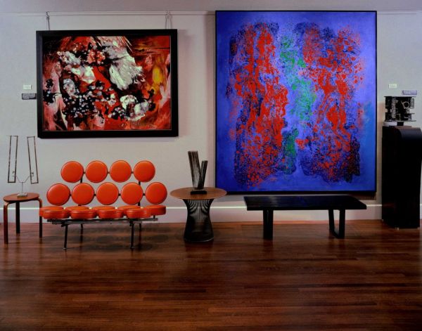 Marshmallow Sofa in bright orange flanked by interesting art work
