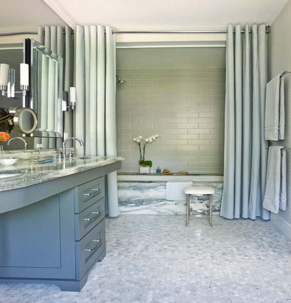 Shower curtains in solid color complement the marble tub