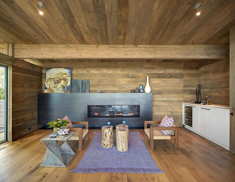 Cozy family room with a sleek fireplace and walls and ceiling with wood paneling