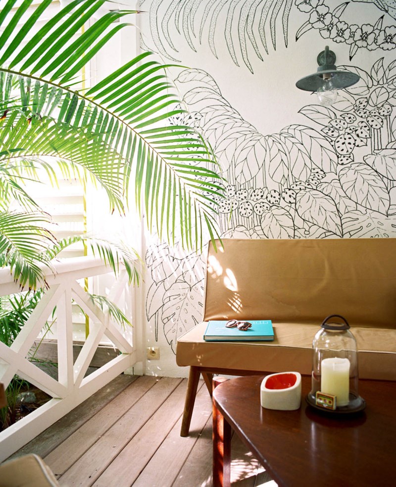 Sitting area with a wall mural and tropical greenery