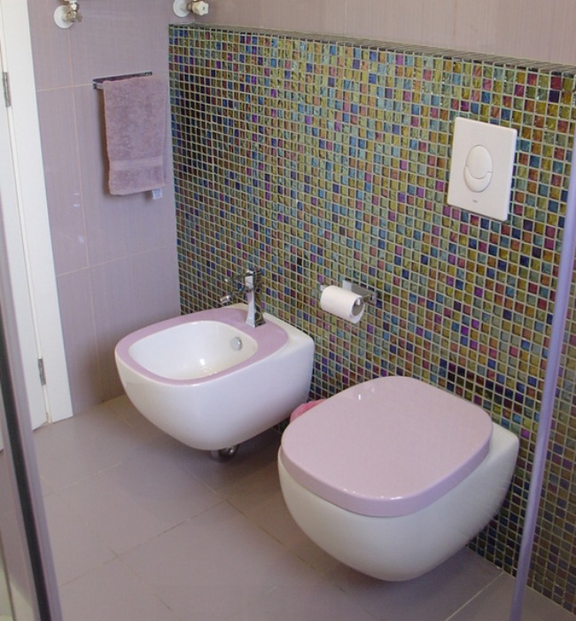 A lavender and white bidet and matching toilet