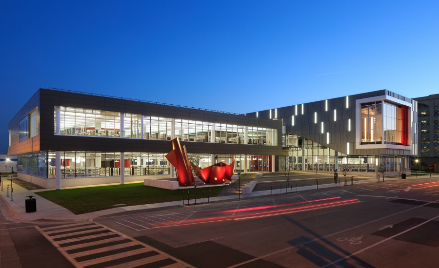 Open space, a sculpture, and banks of windows welcome people into the library