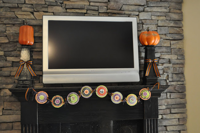 Fireplace mantel with large TV decorated with candlesticks and banner
