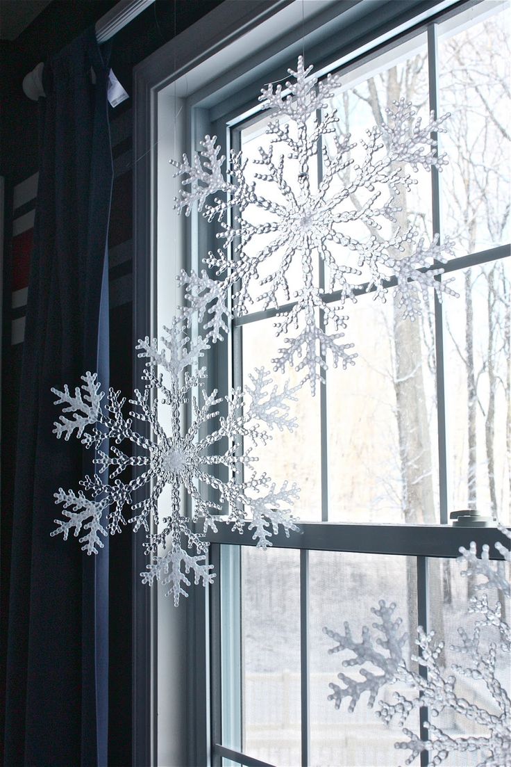 Large snowflakes hung with fishing wire in a window