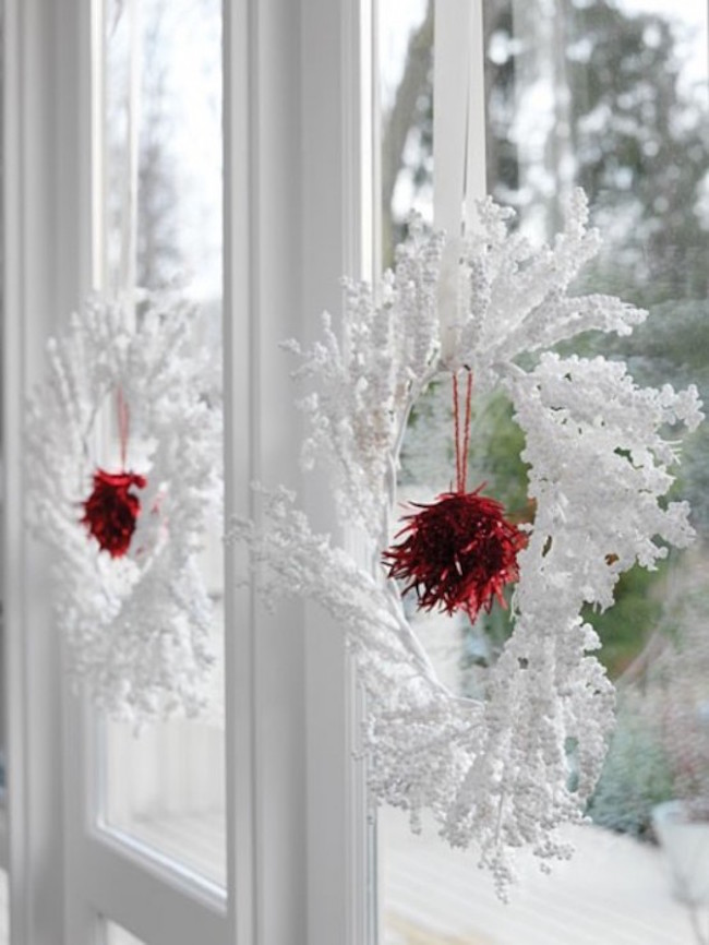Wintery white and red wreaths hung in windows