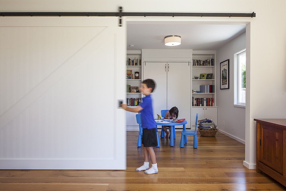 Kids’ study area and playroom delineated from the rest of the home using sliding barn door
