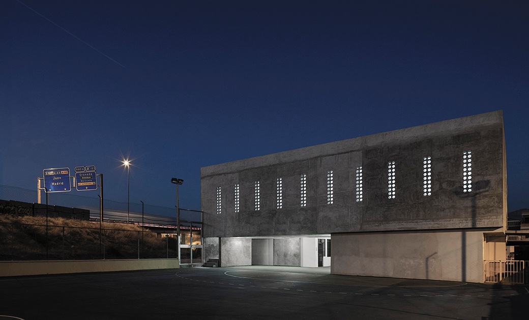 Tiny porthole windows punctuate the multipurpose hall at the Cerrillo de Maracena School in Granada.