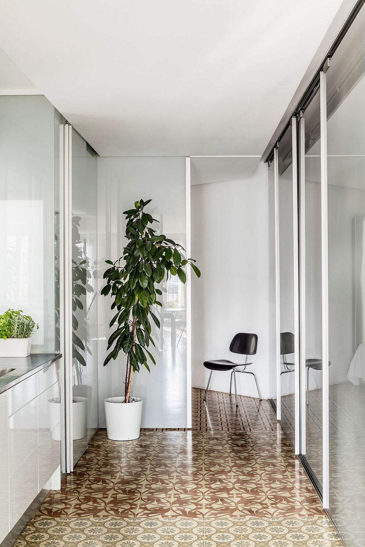 Sliding glass doors and partitions coupled with mosaic flooring inside the renovated Barcelona home