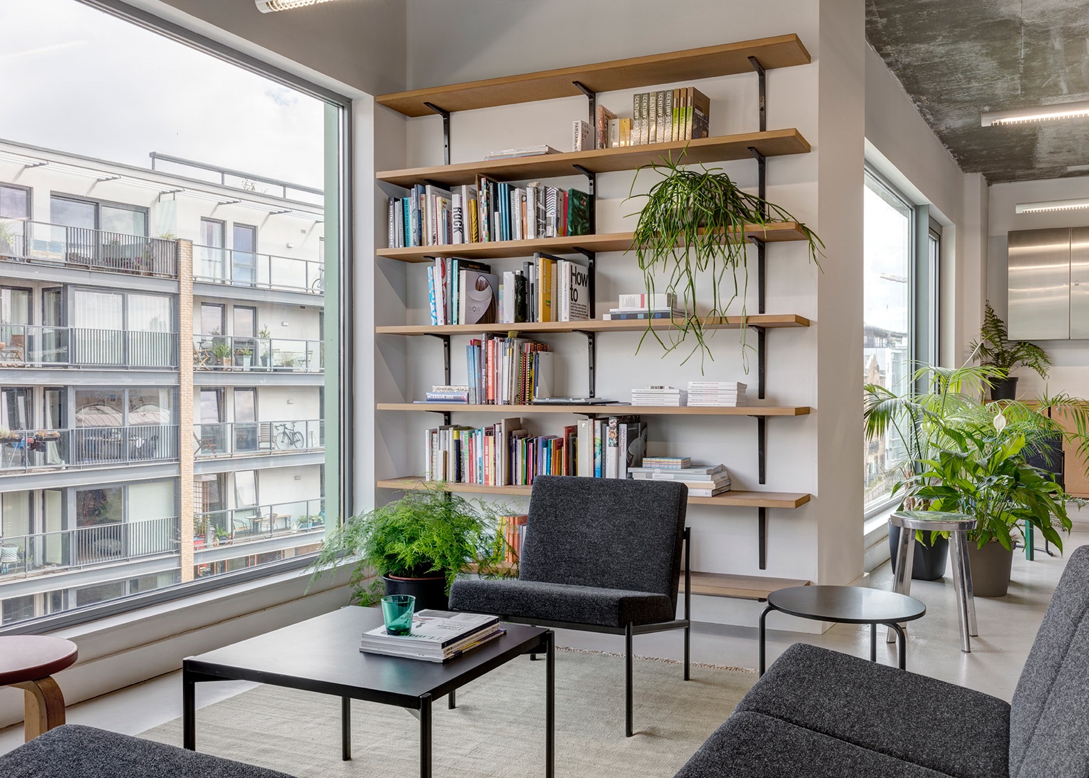 The multi-use lounge area of Dezeen's office includes Ilmari Tapiovaara's Kiki sofa and armchairs and Aino Aalto's 606 Side Table. Image via Dezeen.