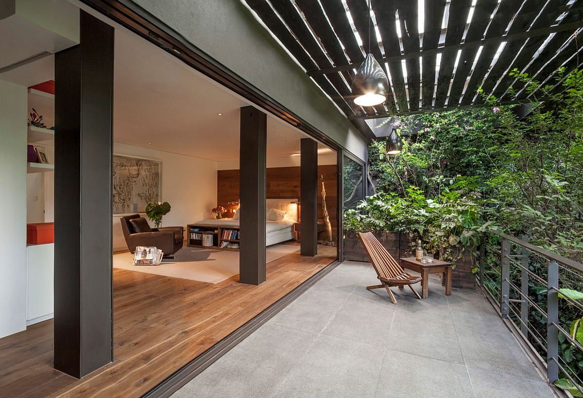 Bedroom opens up completely to the balcony and lush canopy outside