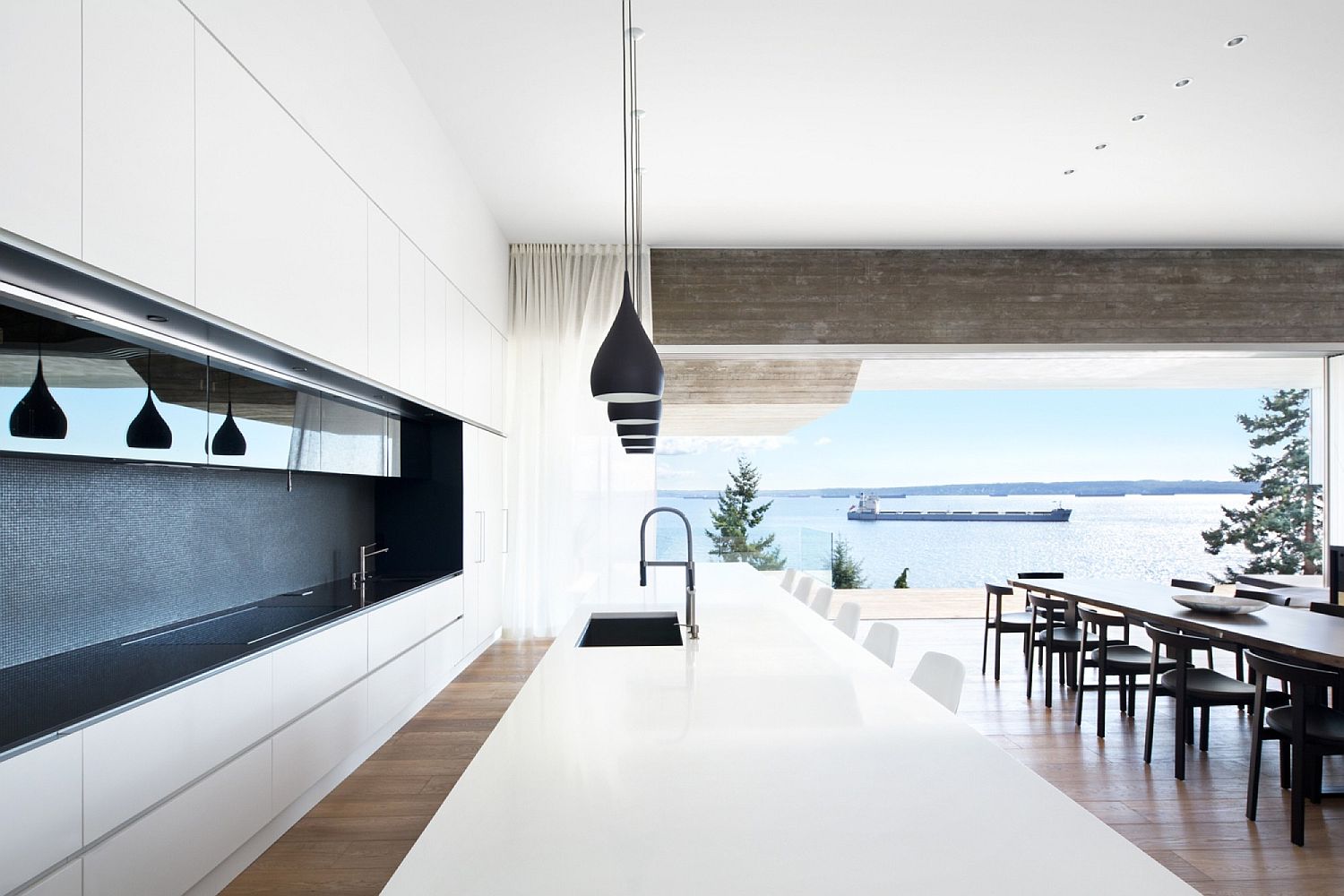 Dashing minimal kitchen in whit with large island and black pendant lights