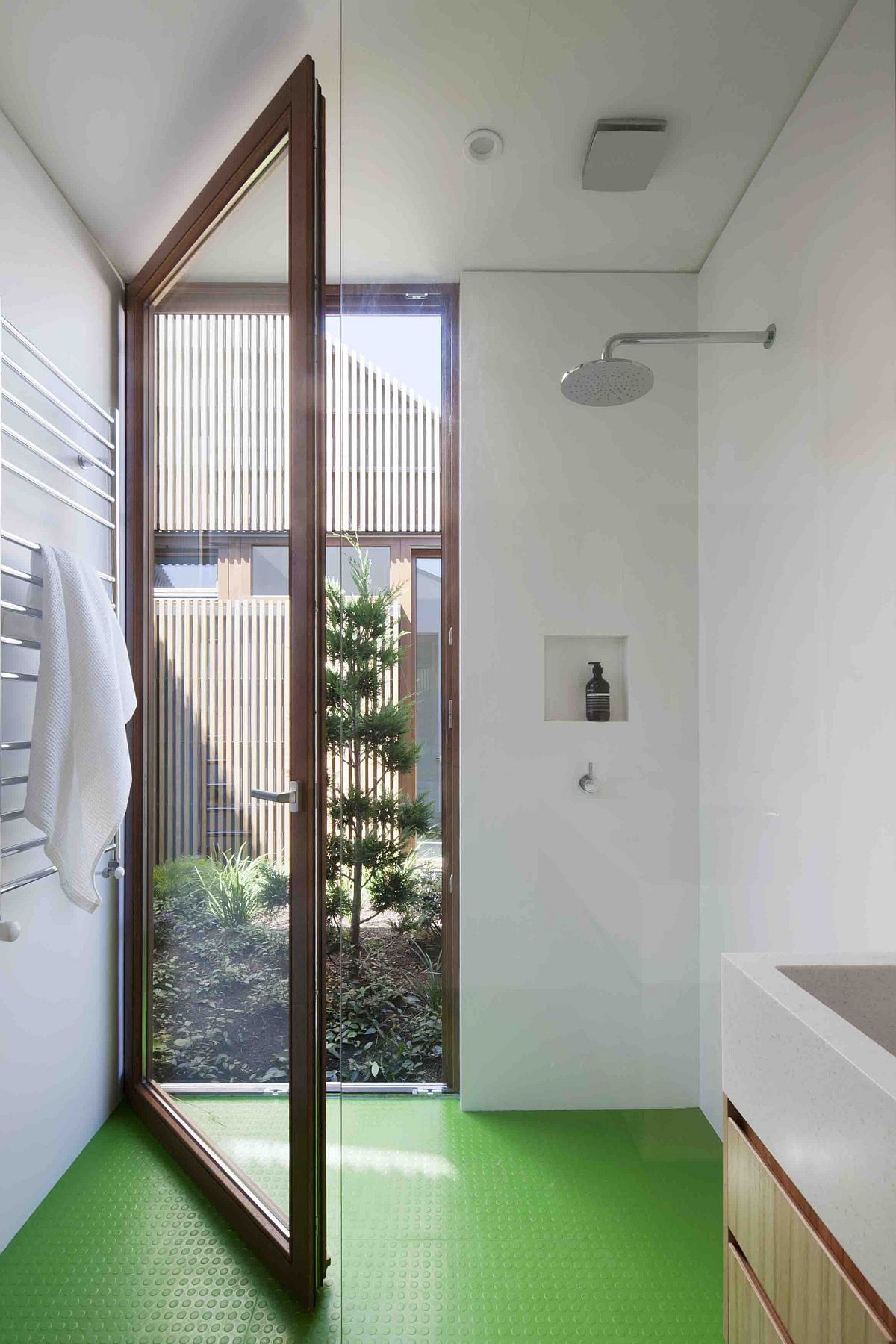 Large glass door connects the bathroom with the exterior